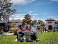 Students sitting at a table on a sunny day